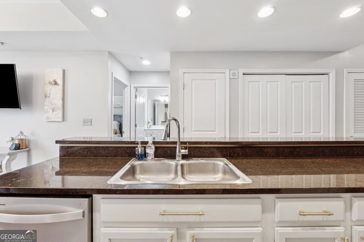 3040 Peachtree Road Northwest, Unit 702 Atlanta, GA 30305 - Photo 16 of 26 a kitchen with granite countertop a sink and white cabinets