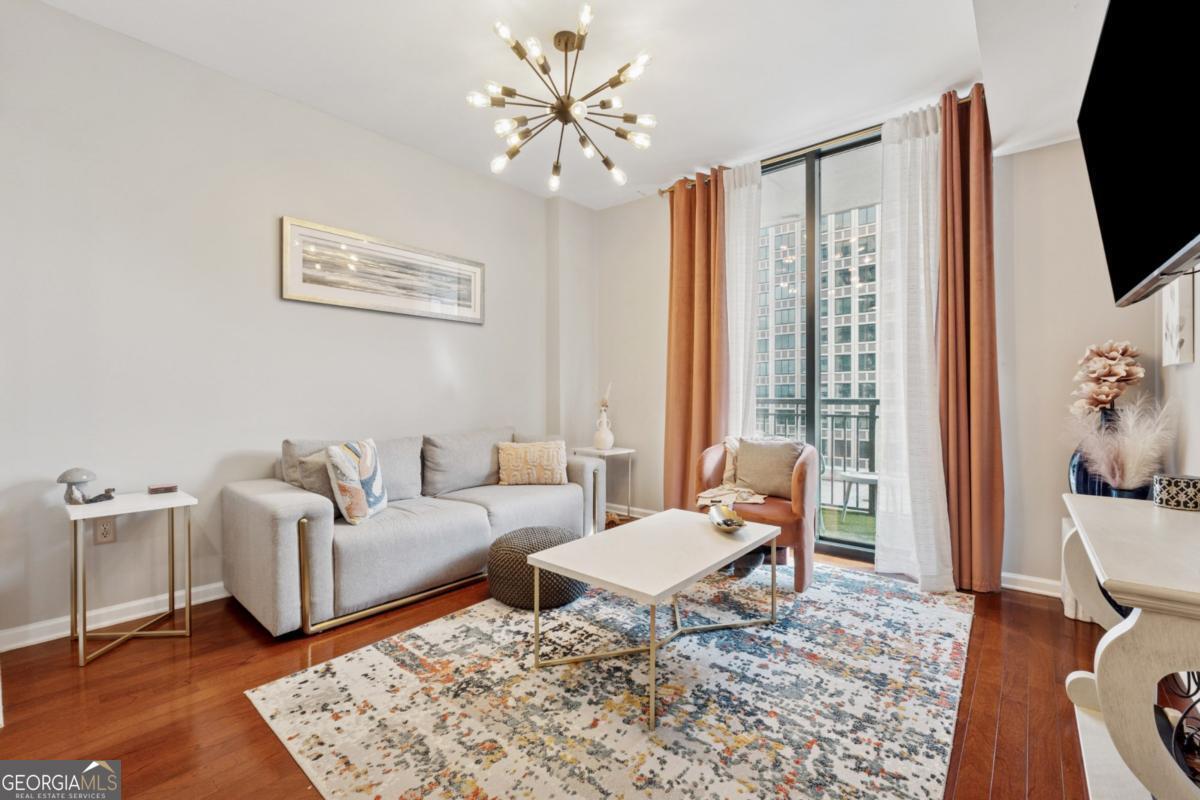 3040 Peachtree Road Northwest, Unit 702 Atlanta, GA 30305 - Photo 20 of 26 a living room with furniture a rug and a flat screen tv