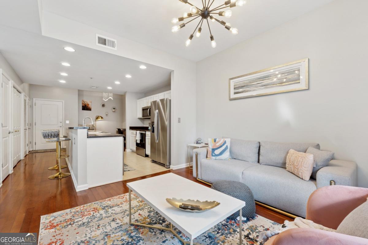3040 Peachtree Road Northwest, Unit 702 Atlanta, GA 30305 - Photo 21 of 26 a living room with furniture and a view of kitchen