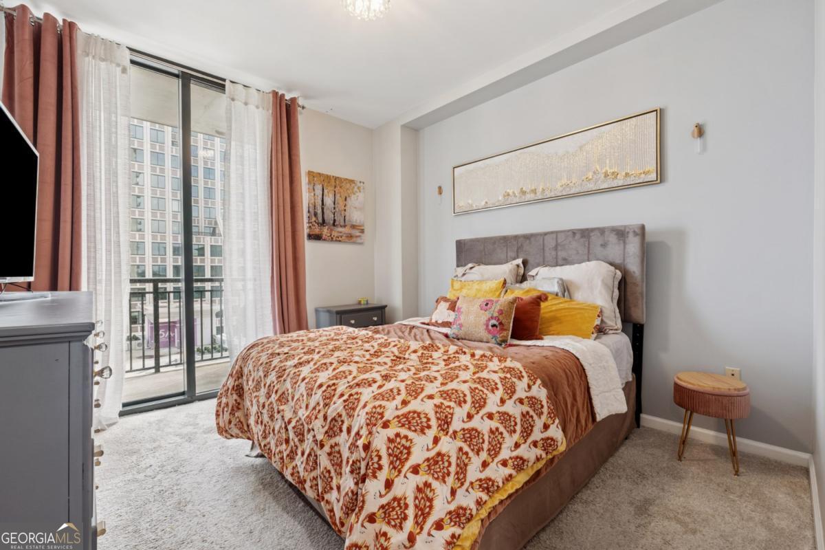 3040 Peachtree Road Northwest, Unit 702 Atlanta, GA 30305 - Photo 22 of 26 a bedroom with a bed and large window