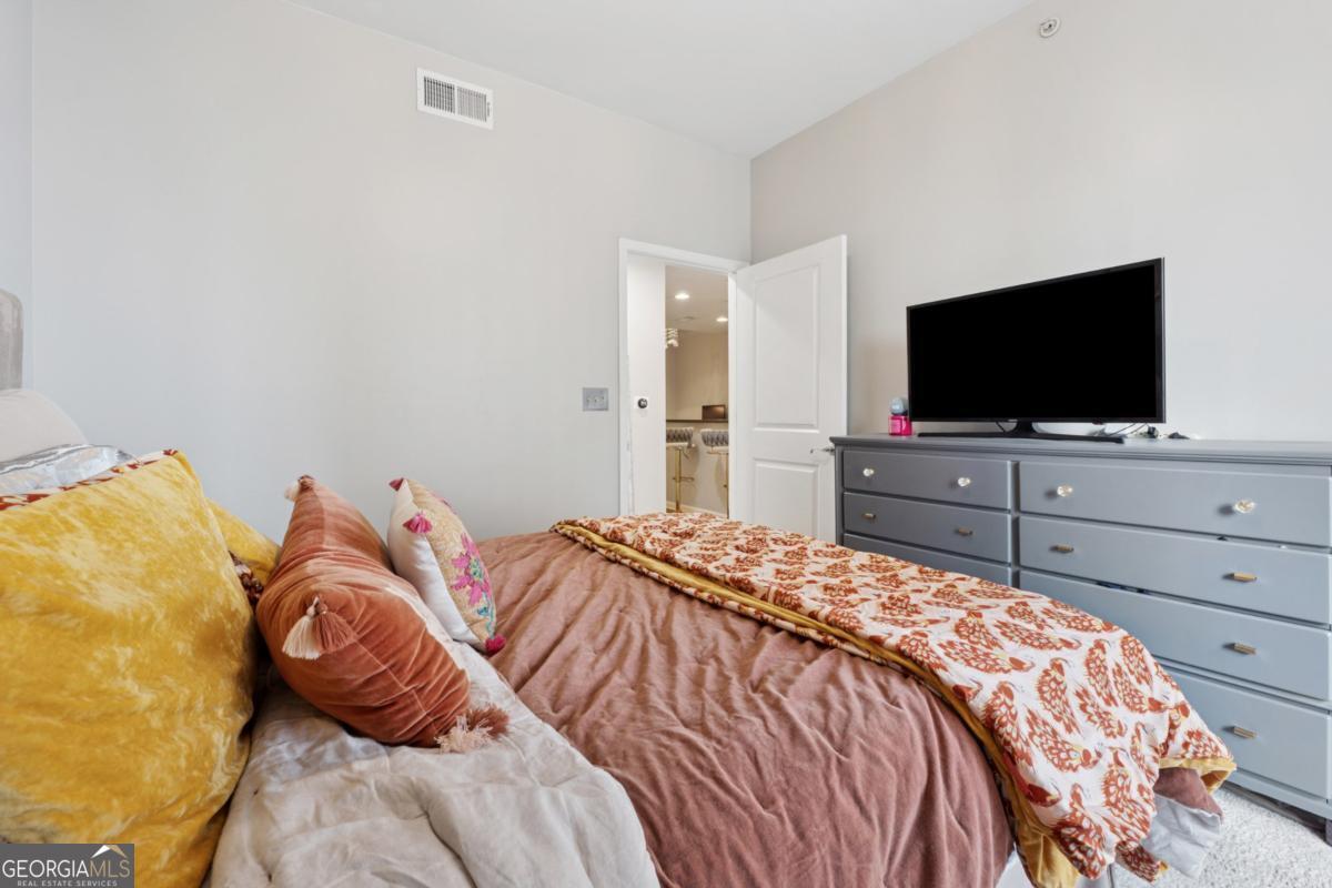 3040 Peachtree Road Northwest, Unit 702 Atlanta, GA 30305 - Photo 23 of 26 a bedroom with a bed and a flat screen tv