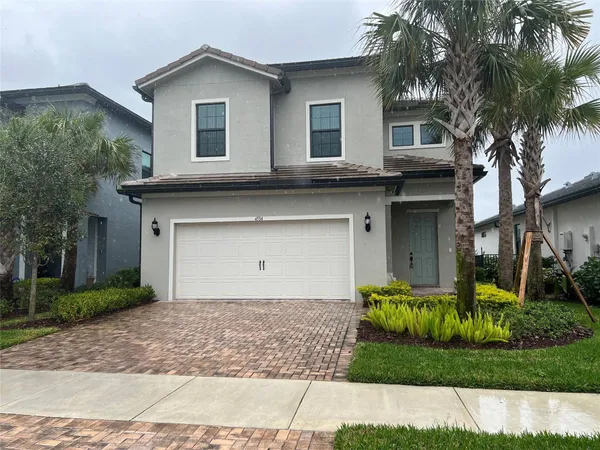 a view of a house with a yard and palm trees