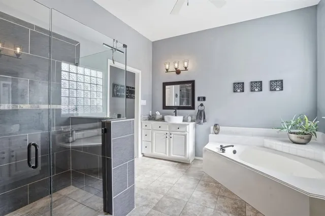a bathroom with a tub sink and mirror