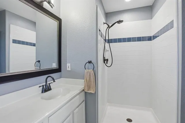 a bathroom with a sink a mirror and a shower