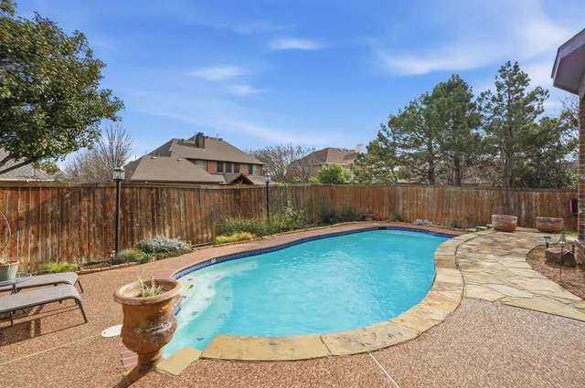 a view of a swimming pool with a patio and a yard