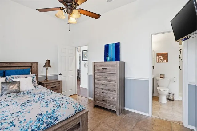 a bedroom with a bed and a flat tv screen on dresser