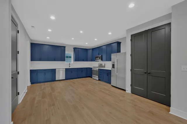 a large kitchen with a refrigerator and a microwave