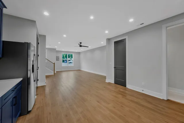 a view of a hallway with wooden floor and windows