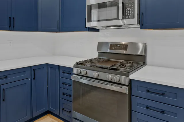 a kitchen with granite countertop cabinets stove and microwave