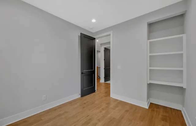 a view of empty room with wooden floor and closet