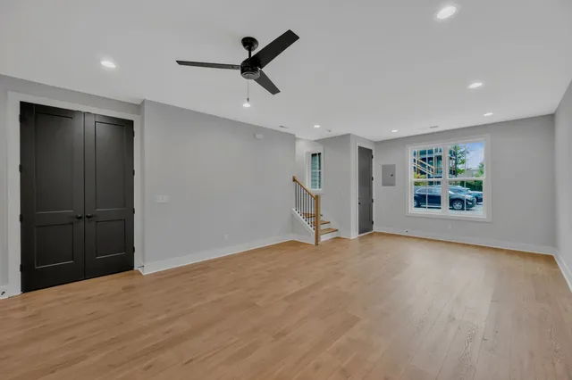 a view of empty room with wooden floor and window