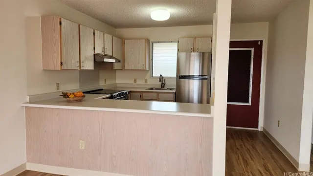 a kitchen with stainless steel appliances granite countertop a refrigerator and a stove