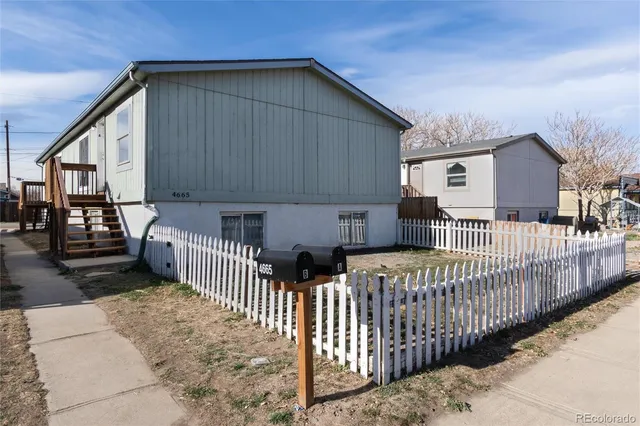 a view of a house with wooden fence