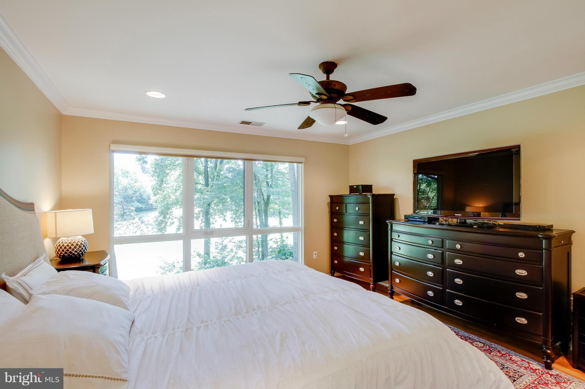 11729 Indian Ridge Road Reston, VA 20191 - Photo 16 of 30 a bedroom with a bed a large window and a flat screen television