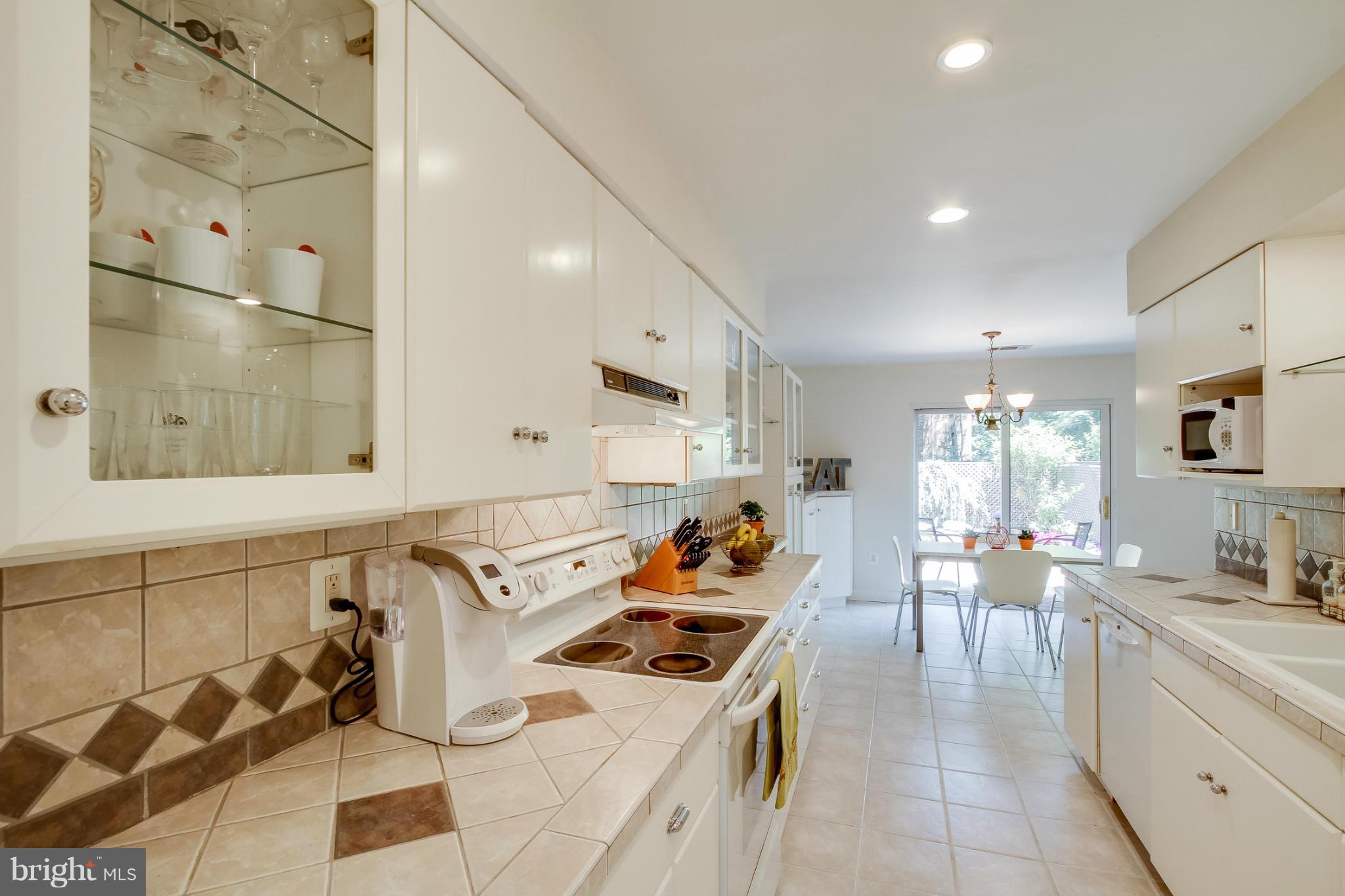 11729 Indian Ridge Road Reston, VA 20191 - Photo 8 of 30 a large white kitchen with a stove a sink a refrigerator and chandelier