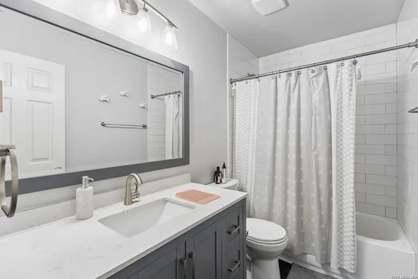 a bathroom with a granite countertop sink toilet and a mirror