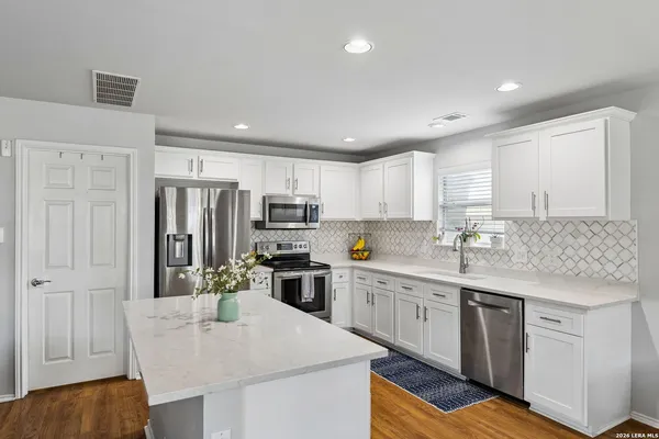 a kitchen with stainless steel appliances granite countertop a kitchen island hardwood floor sink stove and granite counter top
