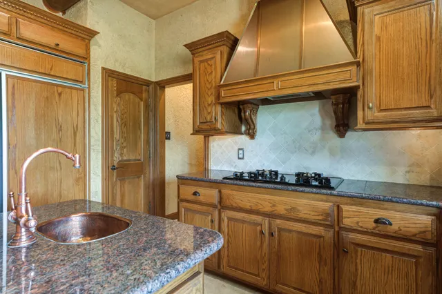 a kitchen with stainless steel appliances granite countertop a sink dishwasher and cabinets with wooden floor