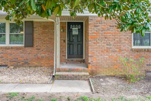 a front view of a house with a tree