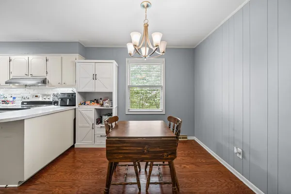 a kitchen with a table chairs a sink dishwasher window and cabinets