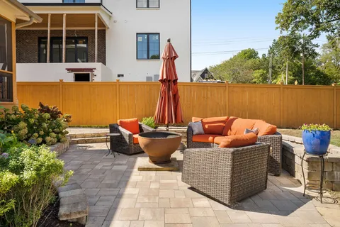 a view of house with a big yard and large trees