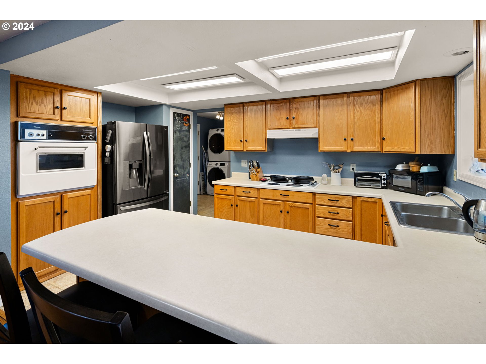 6926 B Street Springfield, OR 97478 - Photo 10 of 29 a kitchen with stainless steel appliances a stove a refrigerator a sink a dining table and chairs