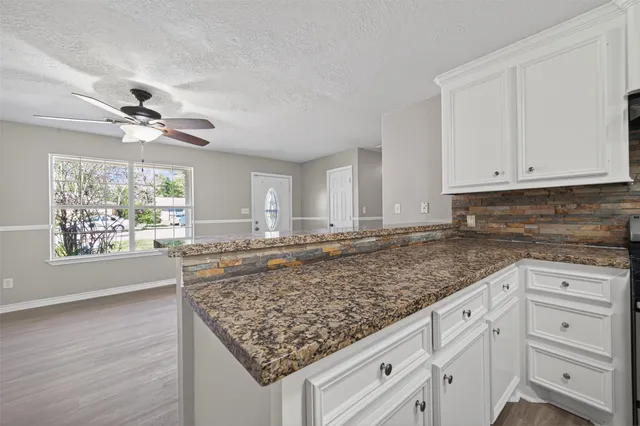 a kitchen with white cabinets and chandelier