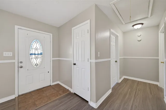 an empty room with wooden floor mirror and windows