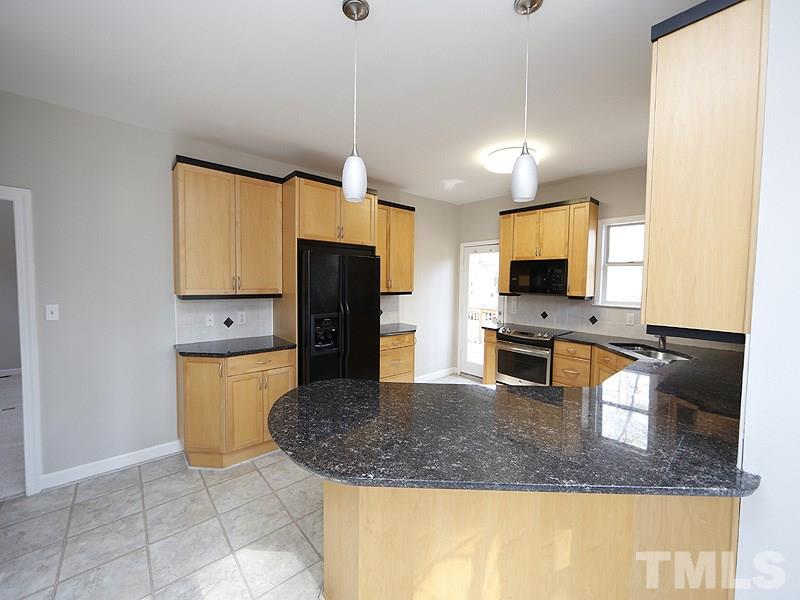5919 Sentinel Drive Raleigh, NC 27609 - Photo 5 of 13 a kitchen with stainless steel appliances granite countertop a sink a microwave a refrigerator and counter space