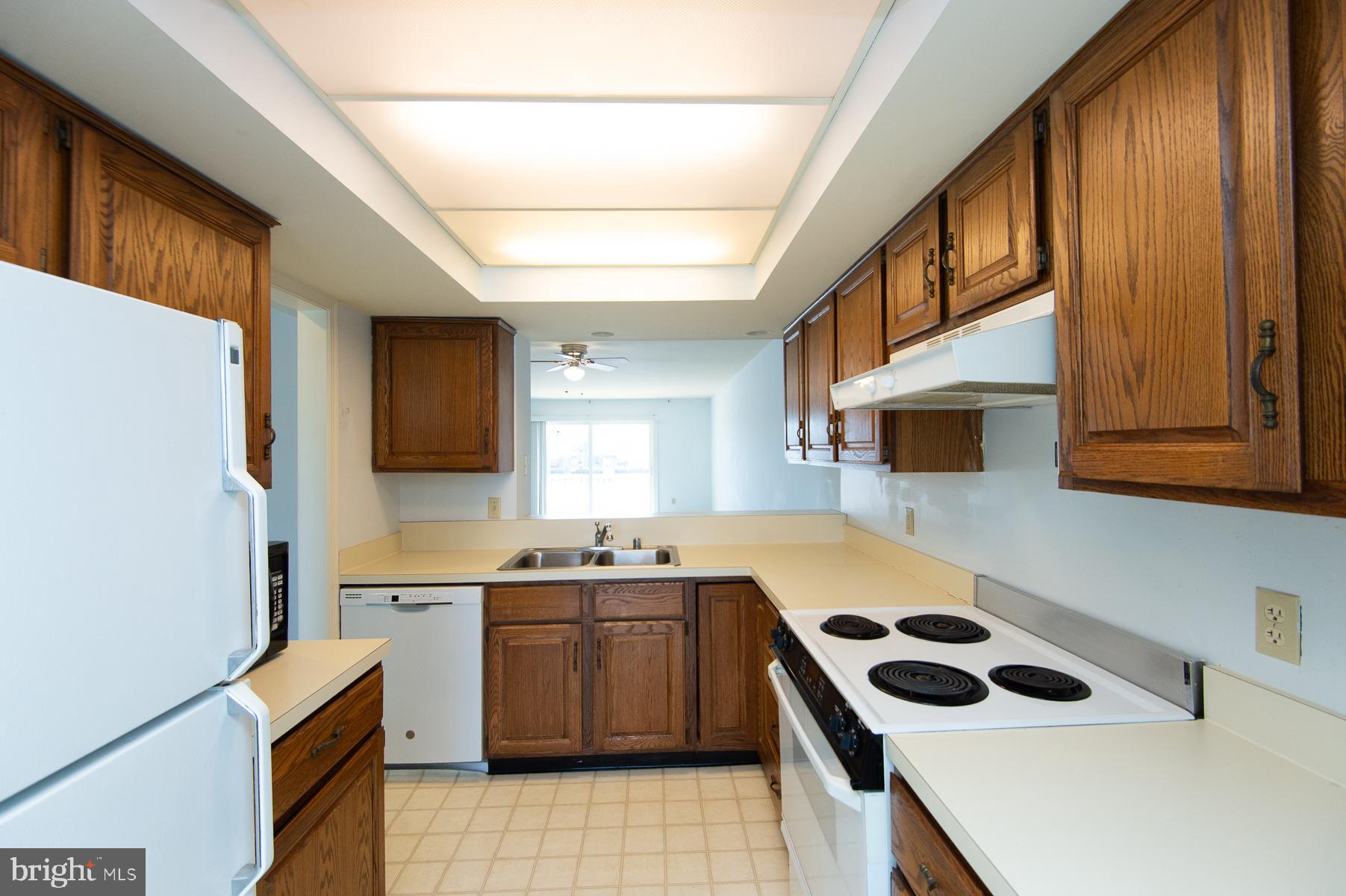 204 Market Square, Unit 12C Cambridge, MD 21613 - Photo 13 of 44 a kitchen that has a sink a stove and a refrigerator