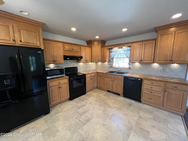 a kitchen with granite countertop stainless steel appliances and cabinets