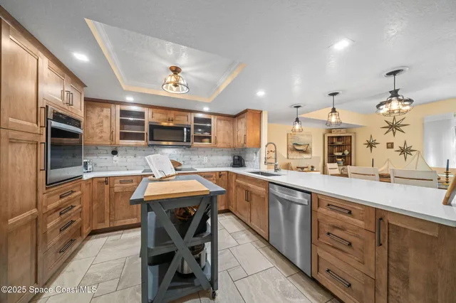 a kitchen with stainless steel appliances granite countertop a sink and a refrigerator
