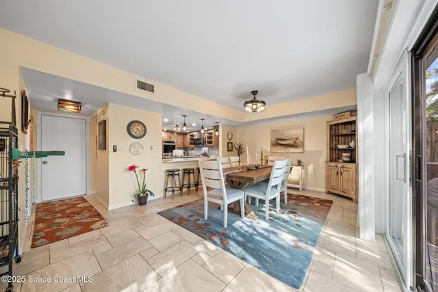 a view of a hallway with a dining table and chairs