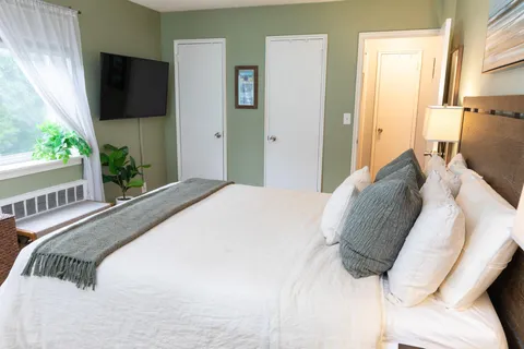 a bedroom with a bed and a flat screen tv