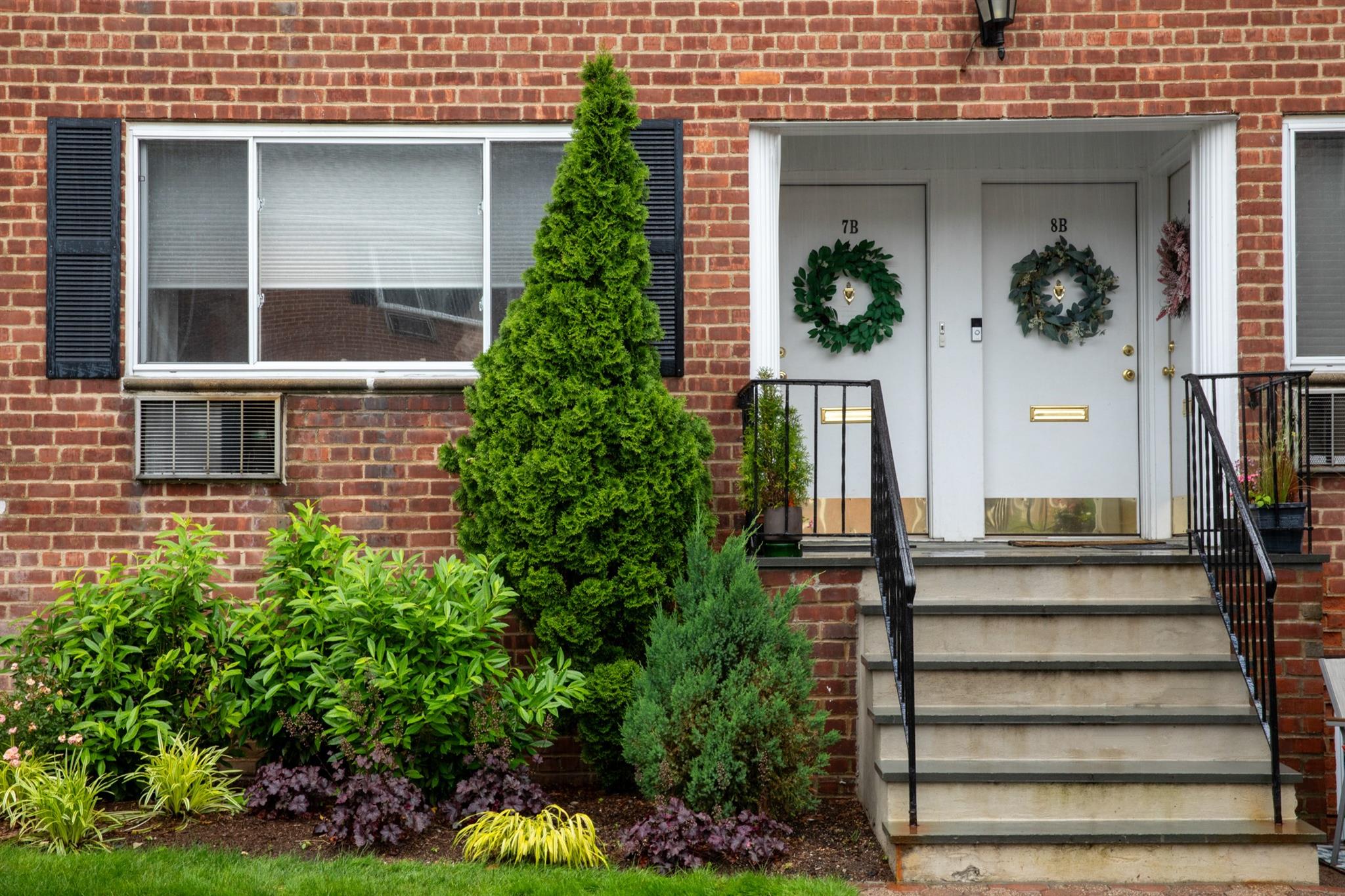 304 Fenimore Road, Unit 7A Mamaroneck, NY 10543 - Photo 9 of 10 a view of a house with potted plants and a bench