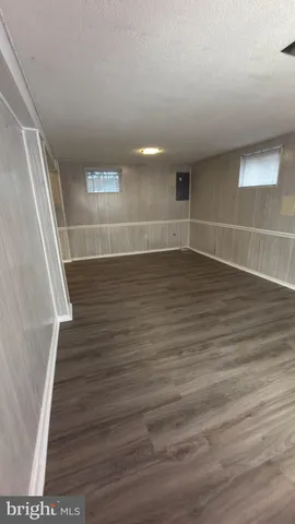 a view of a room with wooden floors and white walls