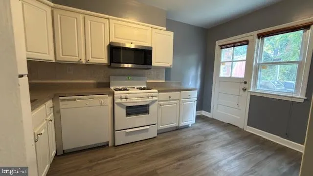 a kitchen with white cabinets stainless steel appliances and sink