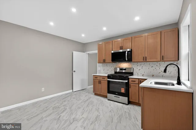 a kitchen with granite countertop stainless steel appliances and wooden cabinets