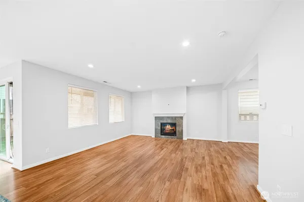a view of empty room with wooden floor and fireplace