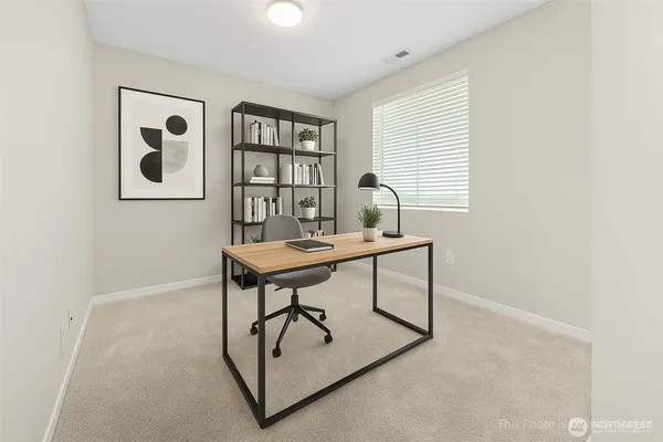 a workspace room with furniture and window
