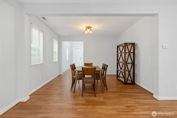 a dining room with furniture a chandelier and wooden floor
