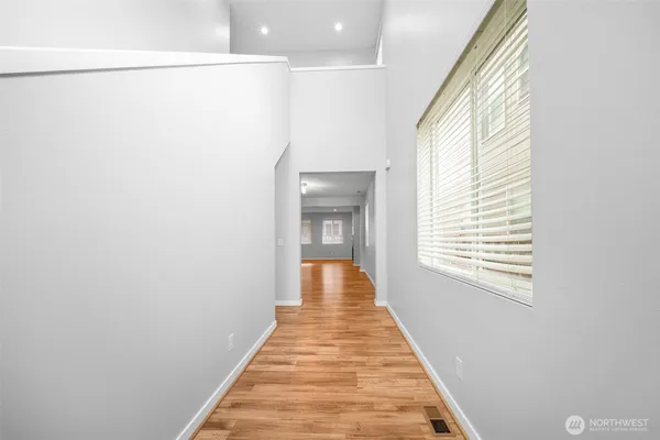 a view of a hallway with wooden floor and staircase