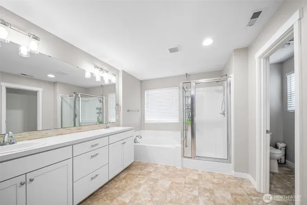 a spacious bathroom with a shower a sink and a mirror