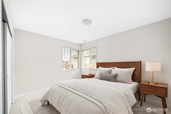 a bedroom with a bed and a lamp next to a window