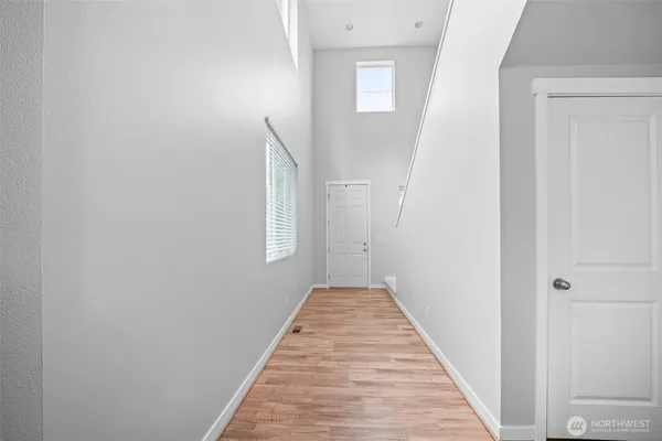 a view of a hallway with wooden floor and staircase