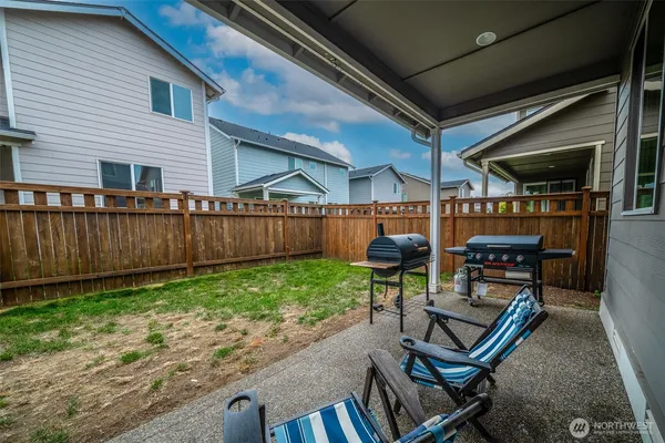 a view of a backyard with chairs and a patio
