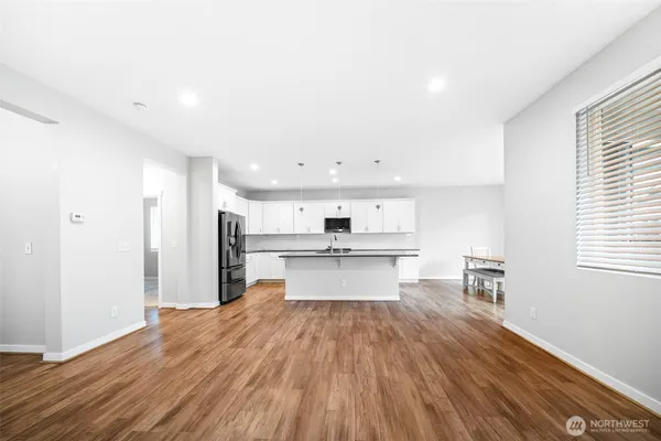 a view of a kitchen with wooden floor and electronic appliances