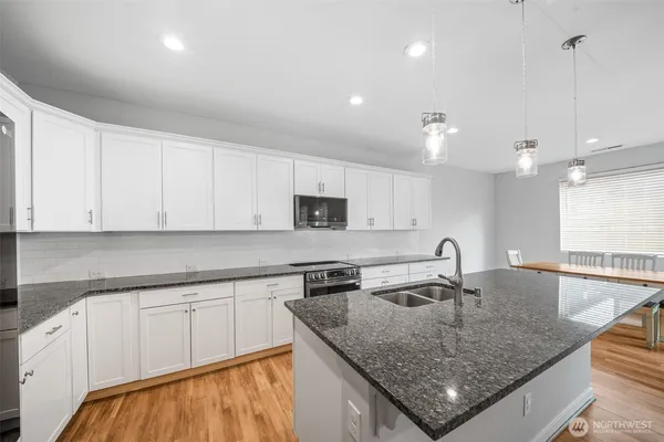 a kitchen with sink a microwave and cabinets