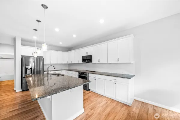 a large kitchen with a center island and stainless steel appliances