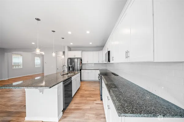 a large kitchen with kitchen island sink stove and cabinets